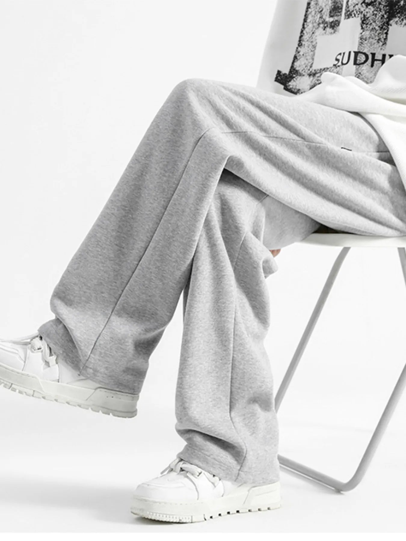 Light gray casual loose fit sweatpants with a wide leg, styled with white sneakers.