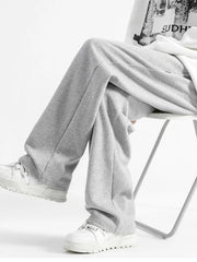 Light gray casual loose fit sweatpants with a wide leg, styled with white sneakers.