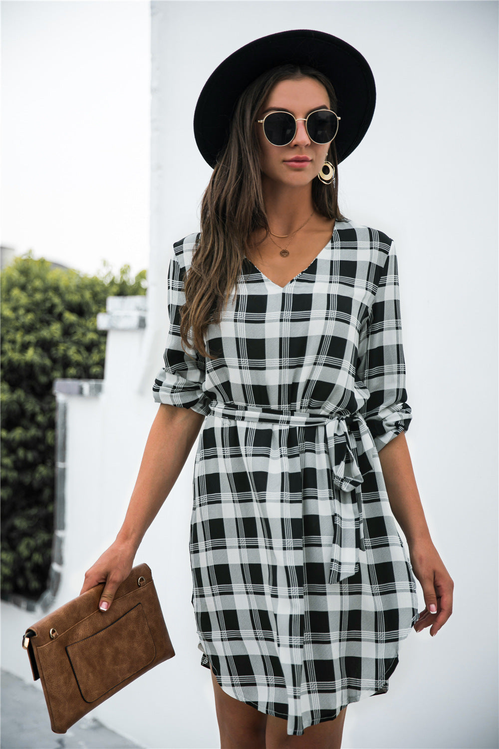 Black plaid shirtdress with V-neck, 3/4 sleeves, and belted waist.