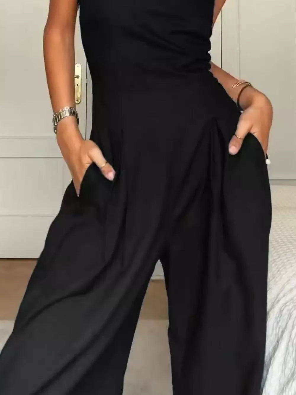 Black strapless wide-leg maternity romper with pockets and pleats.