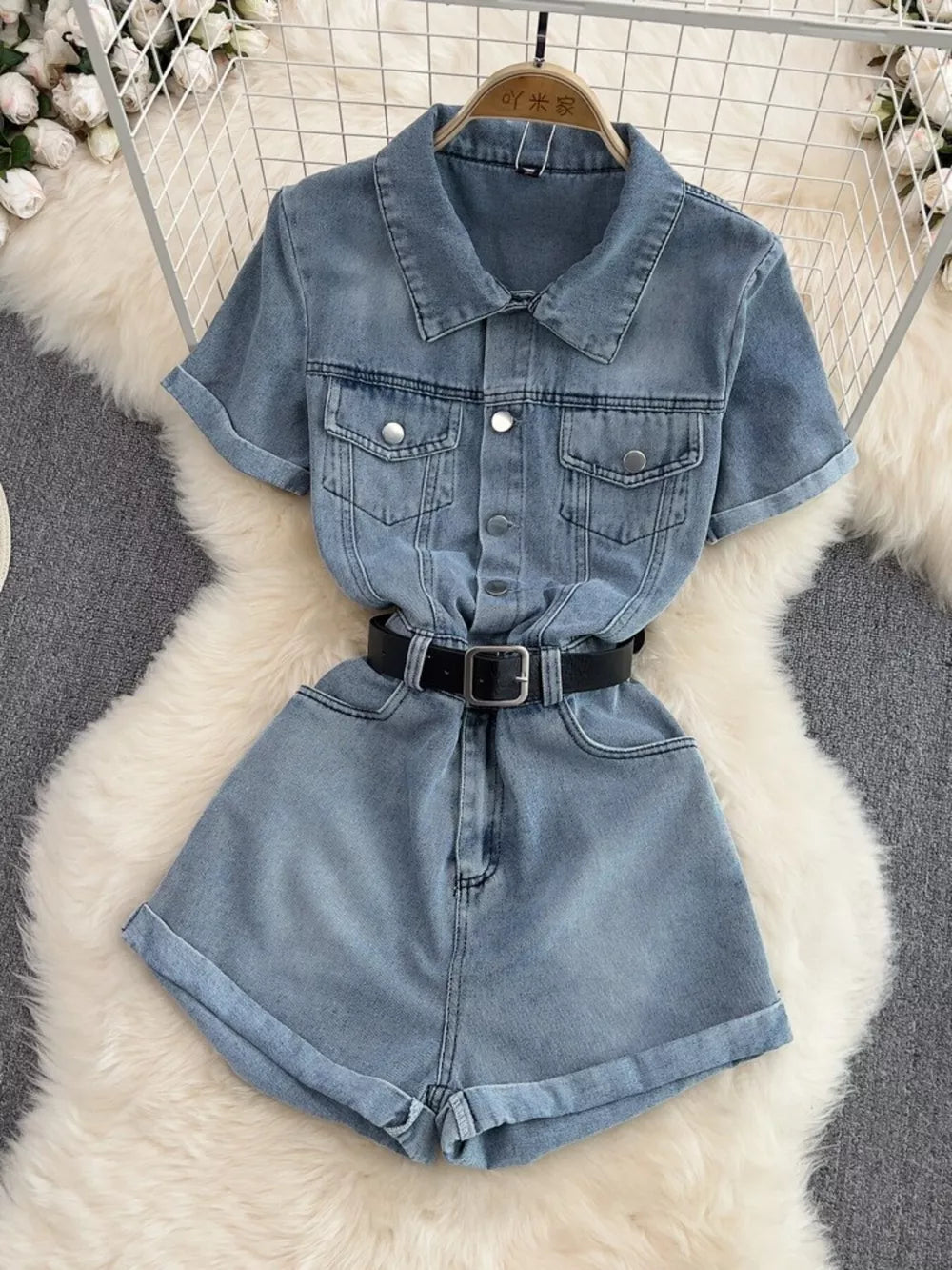 Chic buttoned denim romper with pockets and black belt.