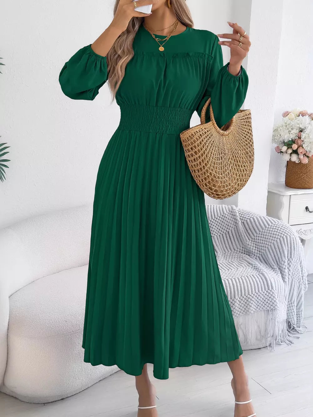 Green midi dress with ruffled smocked waist and pleated skirt.
