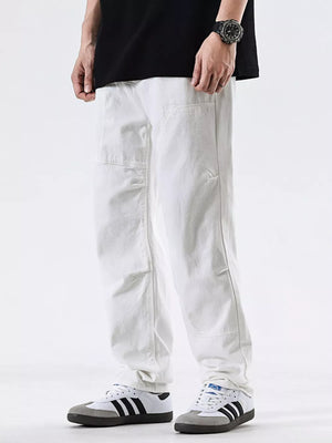 Men's white cotton jeans with a pocketed design and relaxed fit.