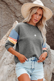 Gray sweatshirt with French blue, pink, and yellow color block sleeves.