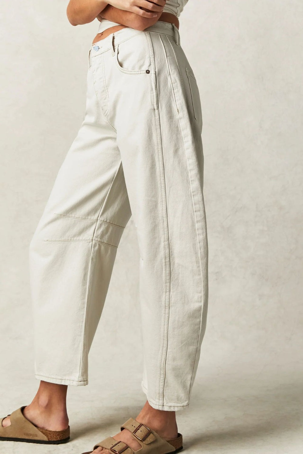 Cream denim barrel leg jeans with seam details and a buttoned fly.