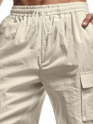Khaki relaxed fit drawstring shorts with utility cargo pockets and elastic waistband.