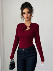 Burgundy long-sleeve tee with asymmetrical cutout and gold ring detail.