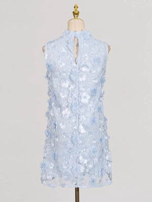 Blue floral applique mini dress with ruffled high neck and buttoned back detail.