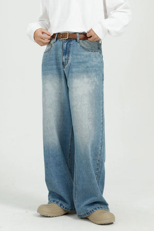 Wide-leg denim jeans in medium wash with pockets and a brown belt.