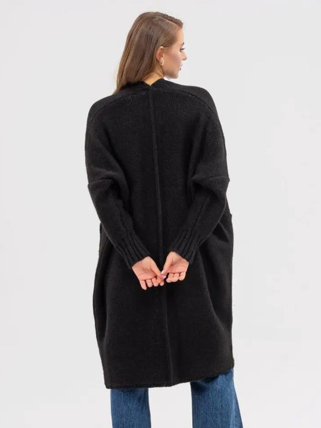 Black oversized acrylic knit cocoon cardigan with pockets and ribbed cuffs.