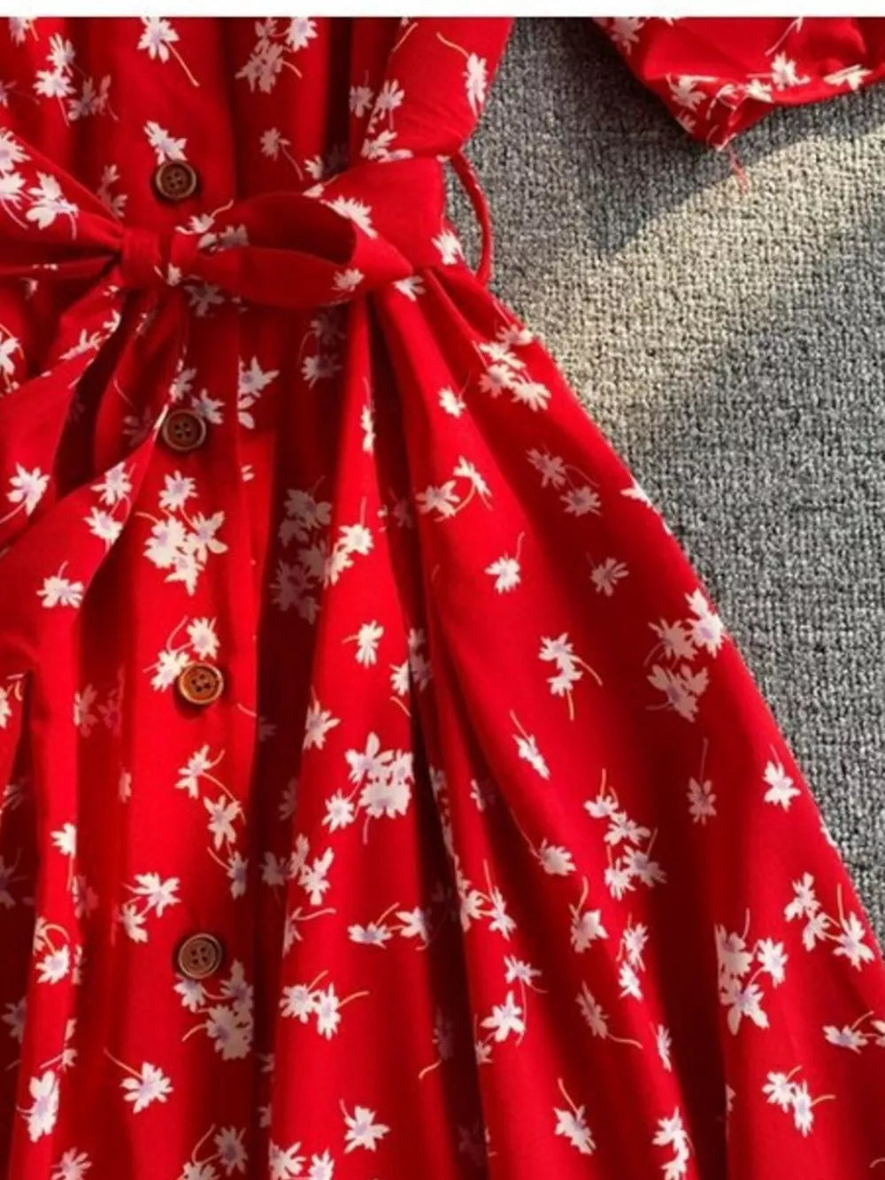 Red floral midi dress with button front, belted waist, and V-neck detail.
