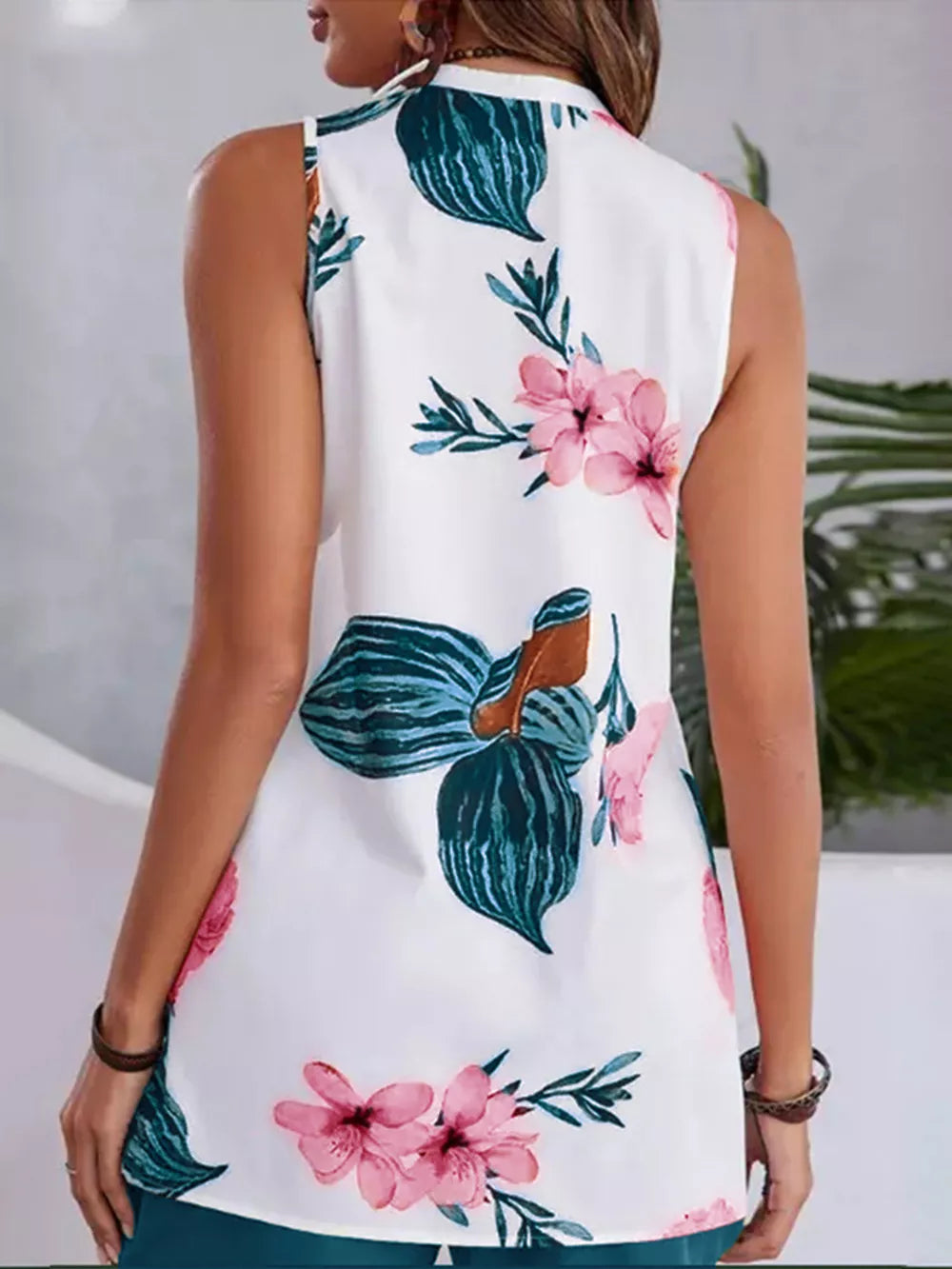 White floral v-neck sleeveless top with teal shorts set.