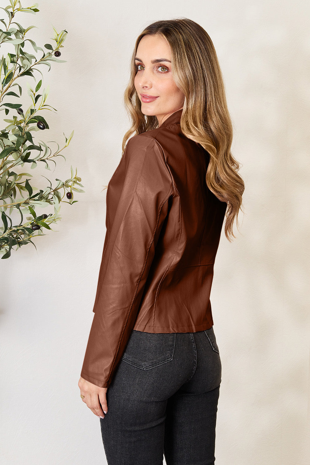Biker jacket in dark camel faux leather with a stand-up collar and fitted cut.