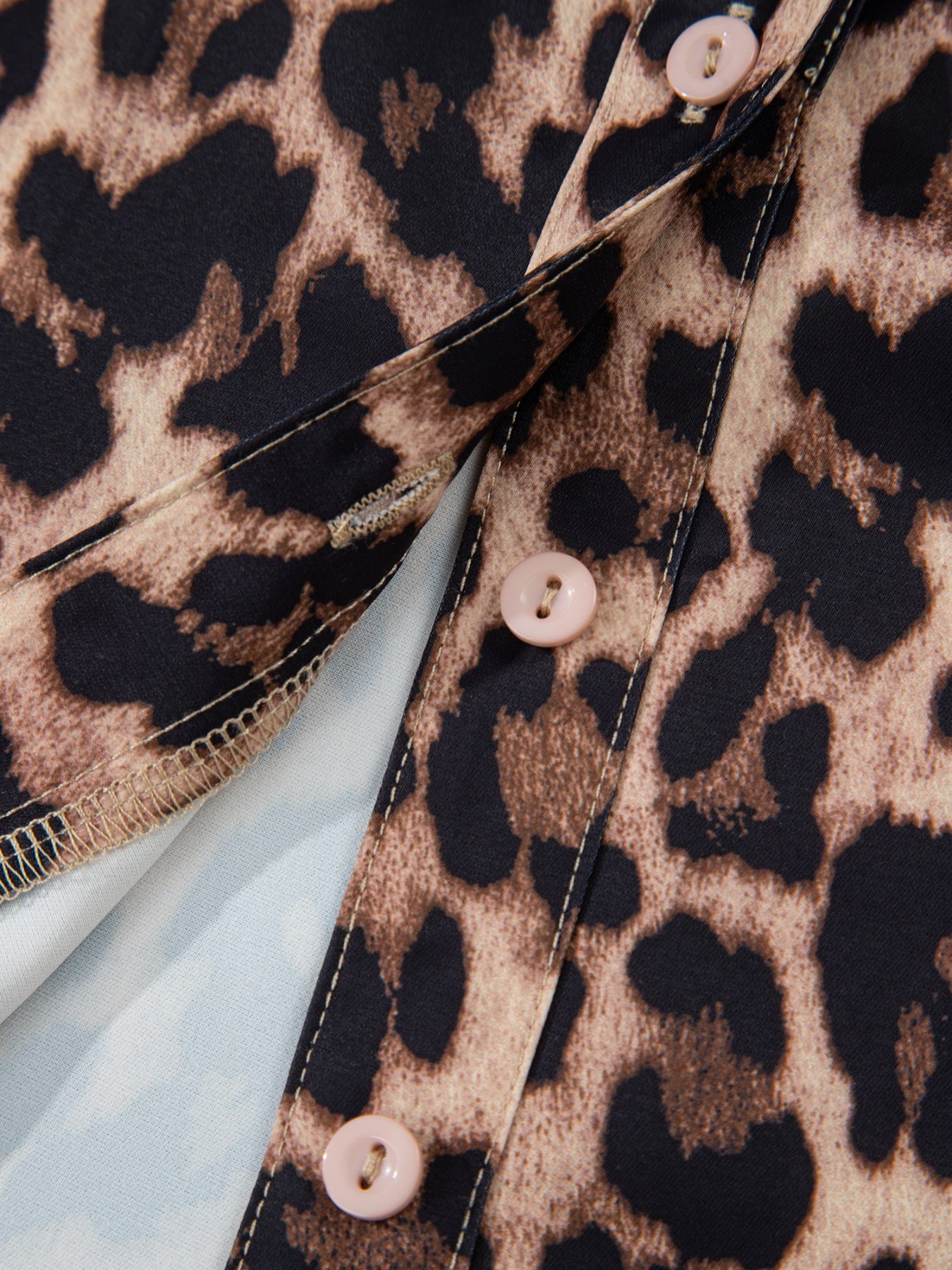 Women's leopard print shirt with button front and lace trim detail.