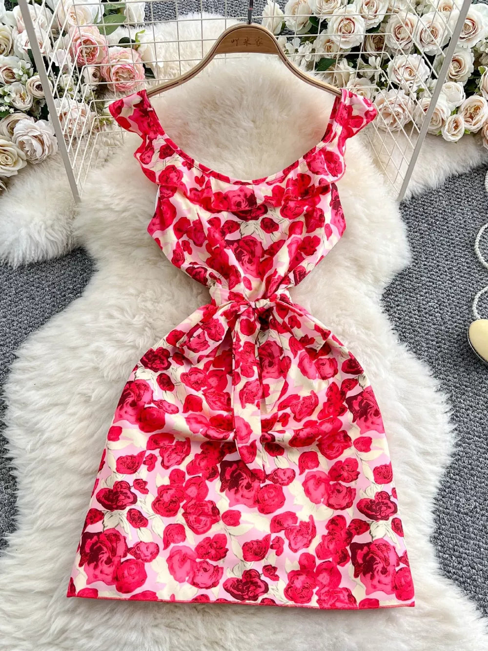 Charming floral ruffle trim mini dress with bow detail and scoop neck.