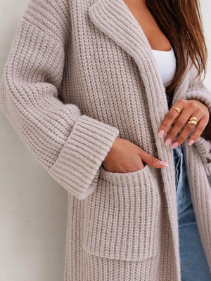 Oversized knit lapel cardigan in cream with ribbed texture and front pockets.