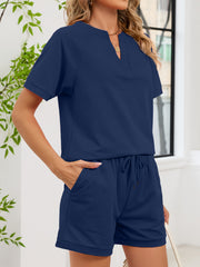 Navy blue loungewear shorts with drawstring and pockets, paired with a matching short-sleeve top.