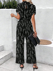 Black wide-leg jumpsuit with raindrop print, tie-back, and belted waist.