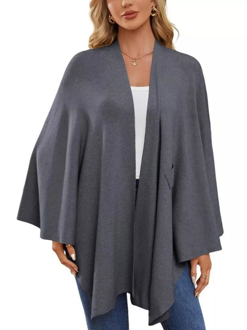 Dark gray knit cape top with draped elegance and a single pocket detail.