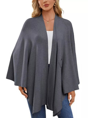 Dark gray knit cape top with draped elegance and a single pocket detail.