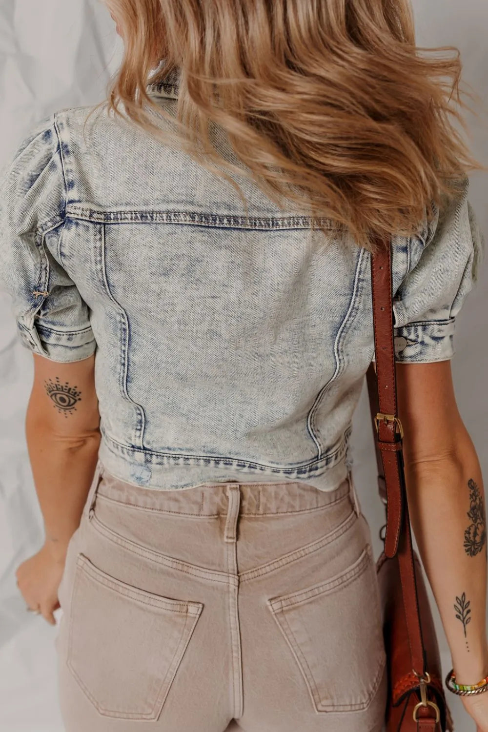 Cropped denim bolero jacket in medium wash with puff sleeves.
