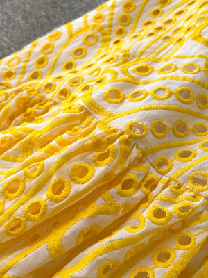 Yellow lace-embroidered tiered cami dress with eyelet details and ruffled tiers.