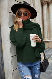 Army green ribbed knit sweater with balloon sleeves and a cowl neck, styled with ripped jeans.