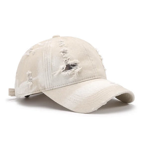 Shredded canvas baseball cap in ivory with distressed details and a curved brim.
