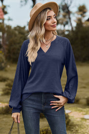 Dark blue waffle knit raglan sweater with laser cut sleeves and v-neck
