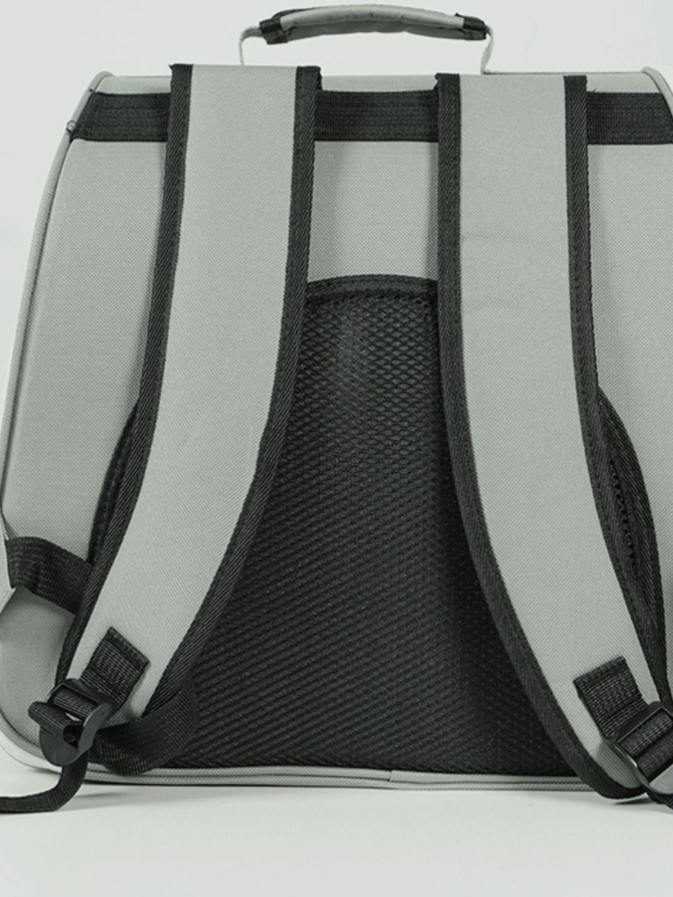 Grey pet carrier backpack with padded straps and mesh back panel.