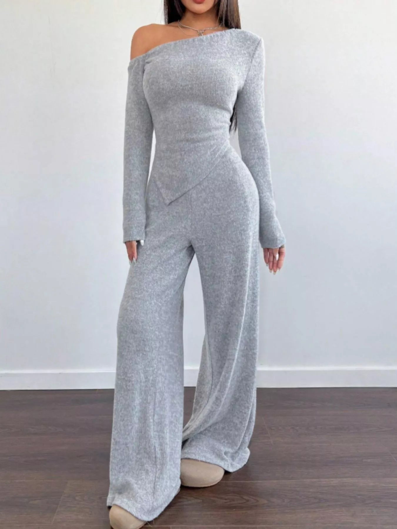 Light gray ribbed knit one-shoulder long sleeve top with asymmetric hem and wide leg pants set.