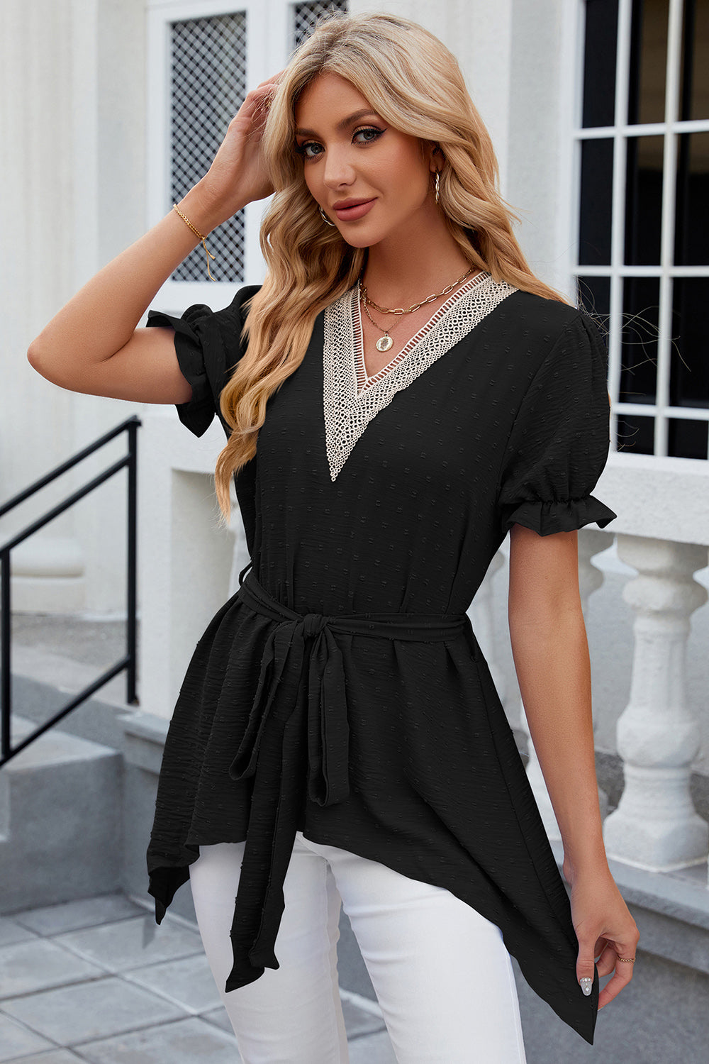 Black dotted swiss blouse with asymmetric hem, lace trim V-neck, tie waist, and ruffled sleeves.