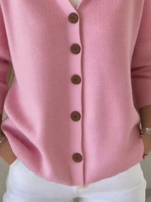 Pink button-front knit cardigan with wooden buttons and ribbed details.