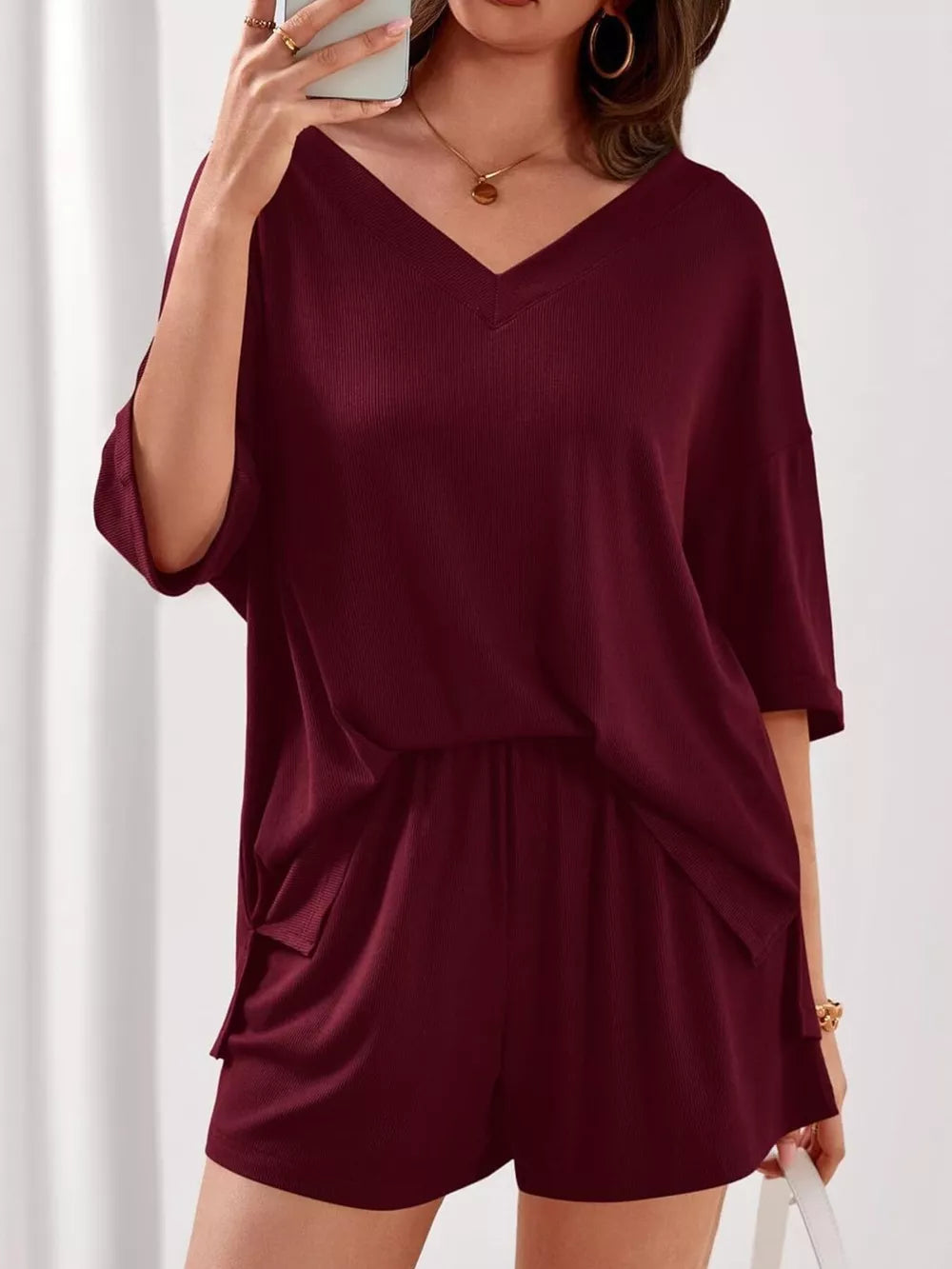Burgundy V-neck two-piece loungewear set with ribbed texture and cuffed sleeves.