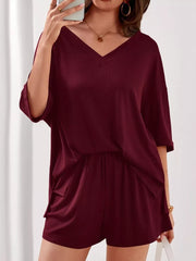 Burgundy V-neck two-piece loungewear set with ribbed texture and cuffed sleeves.