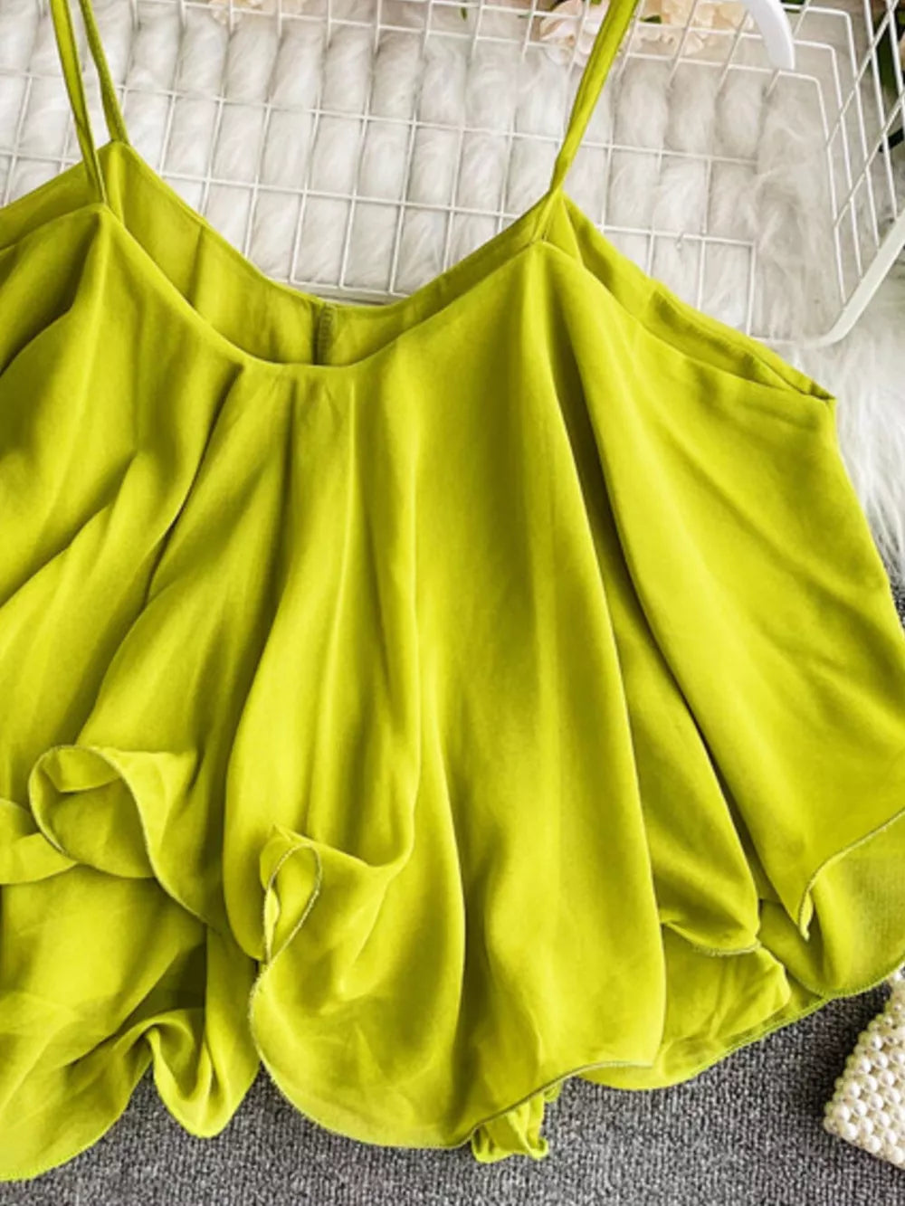 Light green cami with spaghetti straps and delicate ruffles.