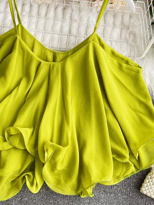Light green cami with spaghetti straps and delicate ruffles.