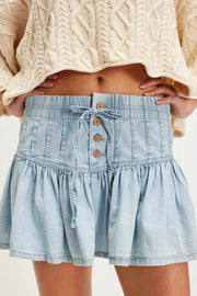 Light blue denim ruffle mini skirt with lace-up front and button details.