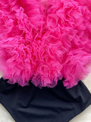 Ruffled V-neck bodysuit in black with a bright pink tulle overlay and lace trim.