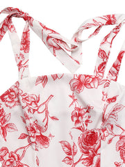 Floral tie strap maxi dress with red floral print on white fabric.