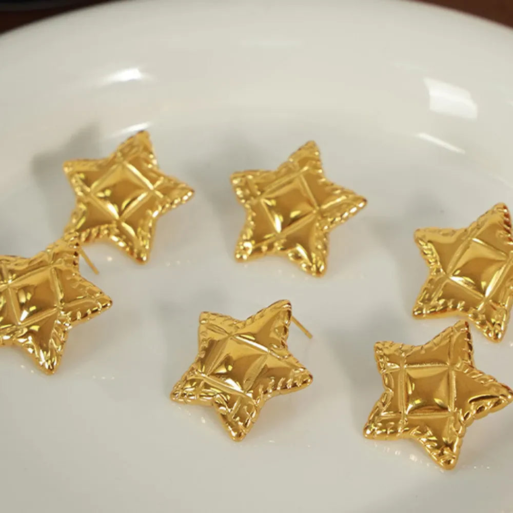 Gold textured celestial star stud earrings with diamond pattern detail.