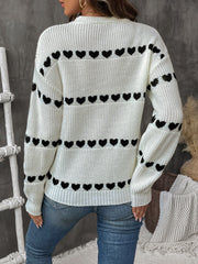 Cream knit sweater with black heart pattern, long sleeves, crew neck.