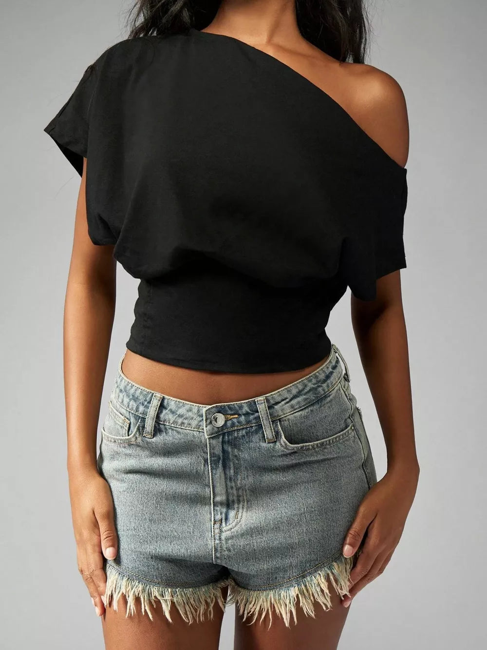 Black asymmetrical crop t-shirt with draped fit and short sleeves.