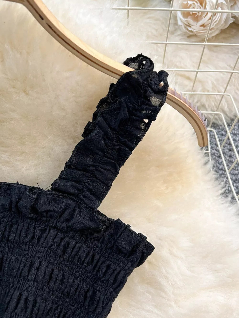 Black ruffled crop top with eyelet trim detail.