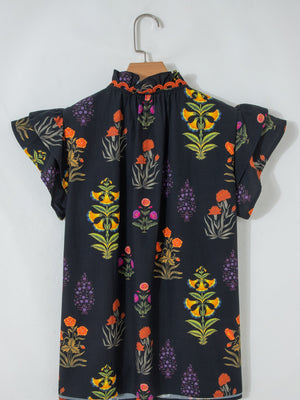 Black cotton maternity shirt with colorful floral print, ruffled short sleeves, and a frilled V-neckline.