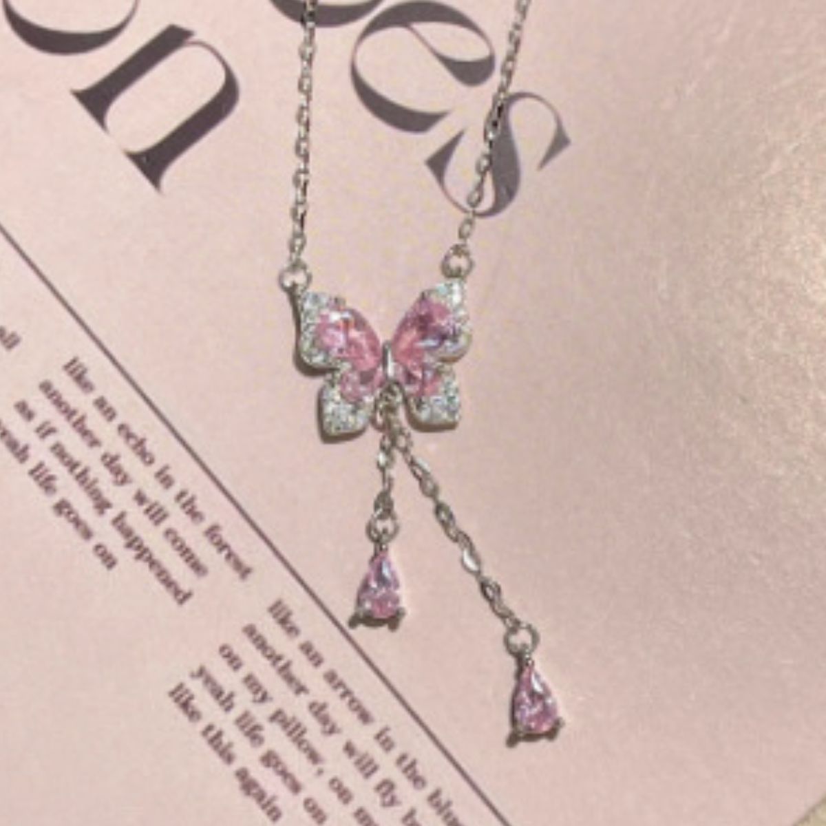 Sparkling butterfly pendant necklace with pink stones and silver chain.