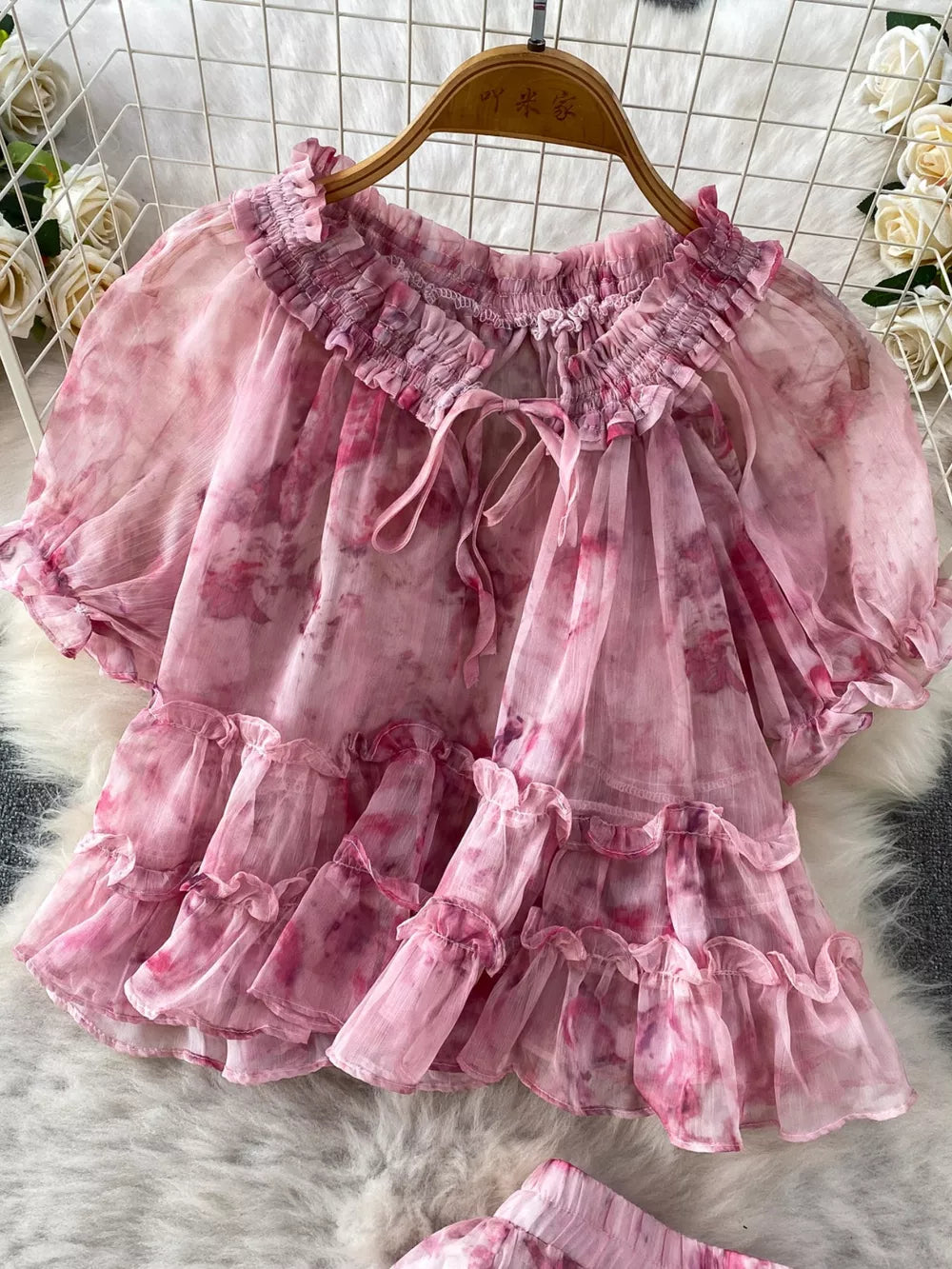 Pink floral ruffle bikini top with bow detail and smocked neckline.