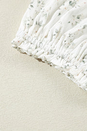 White floral smocked bodice jumpsuit with ruffled hem detail