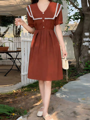Brown short sleeve midi dress with lace-trimmed sailor collar and decorative buttons.