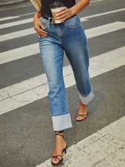 Light wash denim jeans with cuffed hems and wide legs.